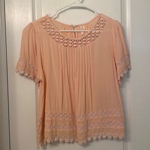 Salmon blouse with detailed sleeves.